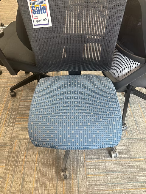 Blue and black office chair on a light-colored carpet, with a mesh back and patterned seat.