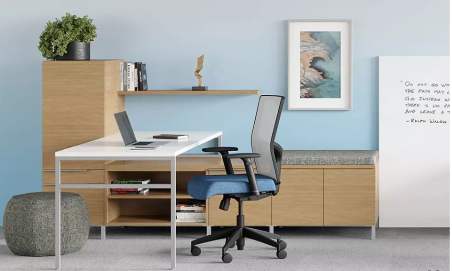 Modern office space with desk, chair, and storage cabinets, in front of a blue wall.