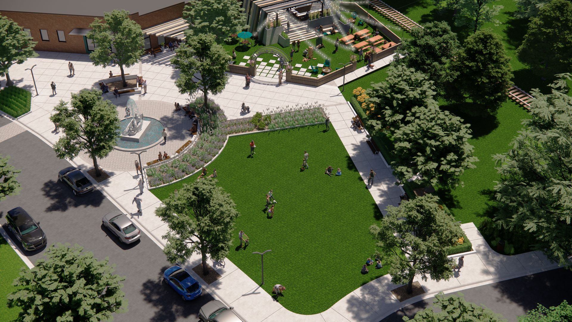 Aerial view of a park with a fountain, green space, trees, and people walking. Cars parked on the street.