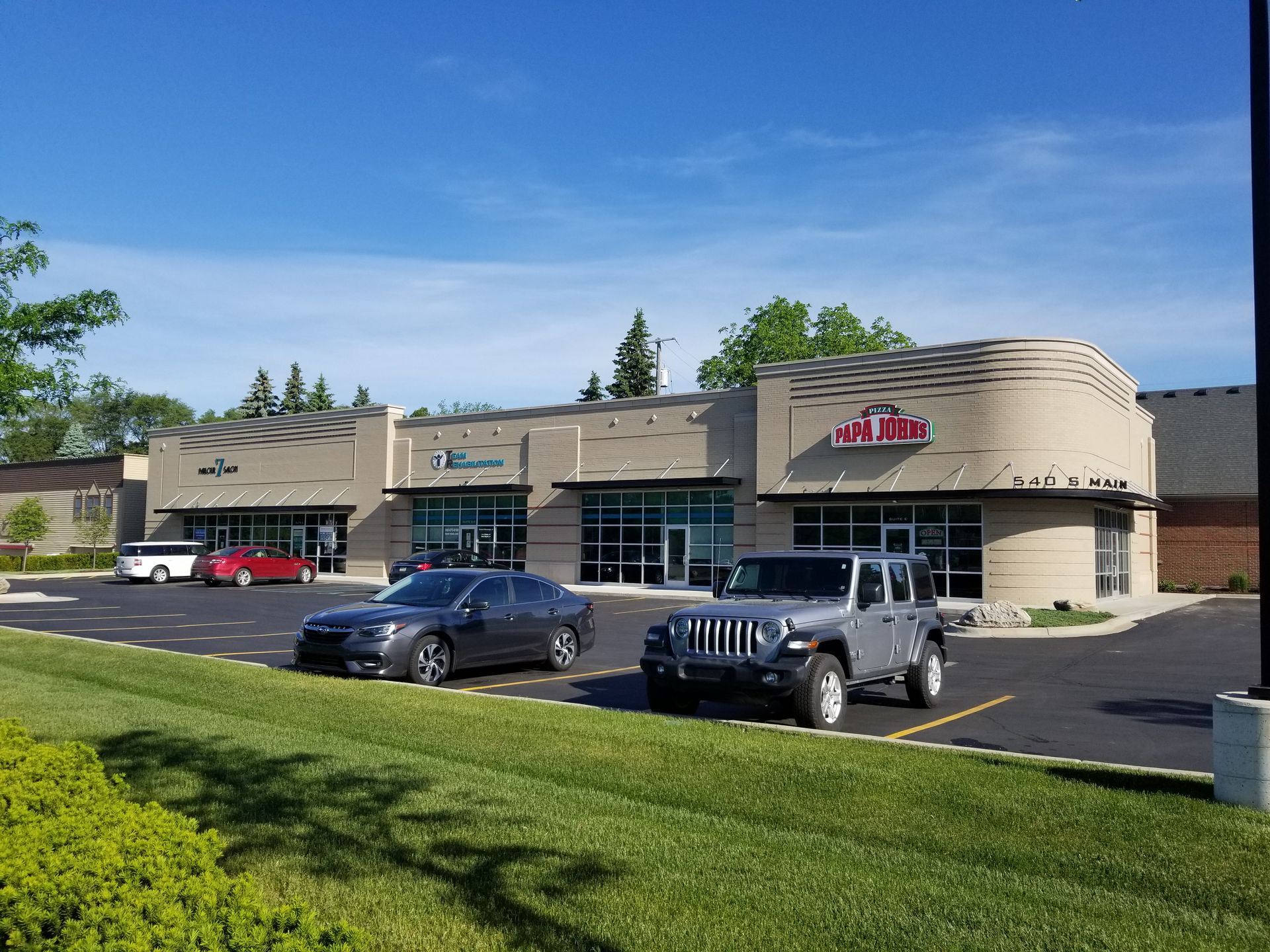 A couple of cars are parked in front of a building.
