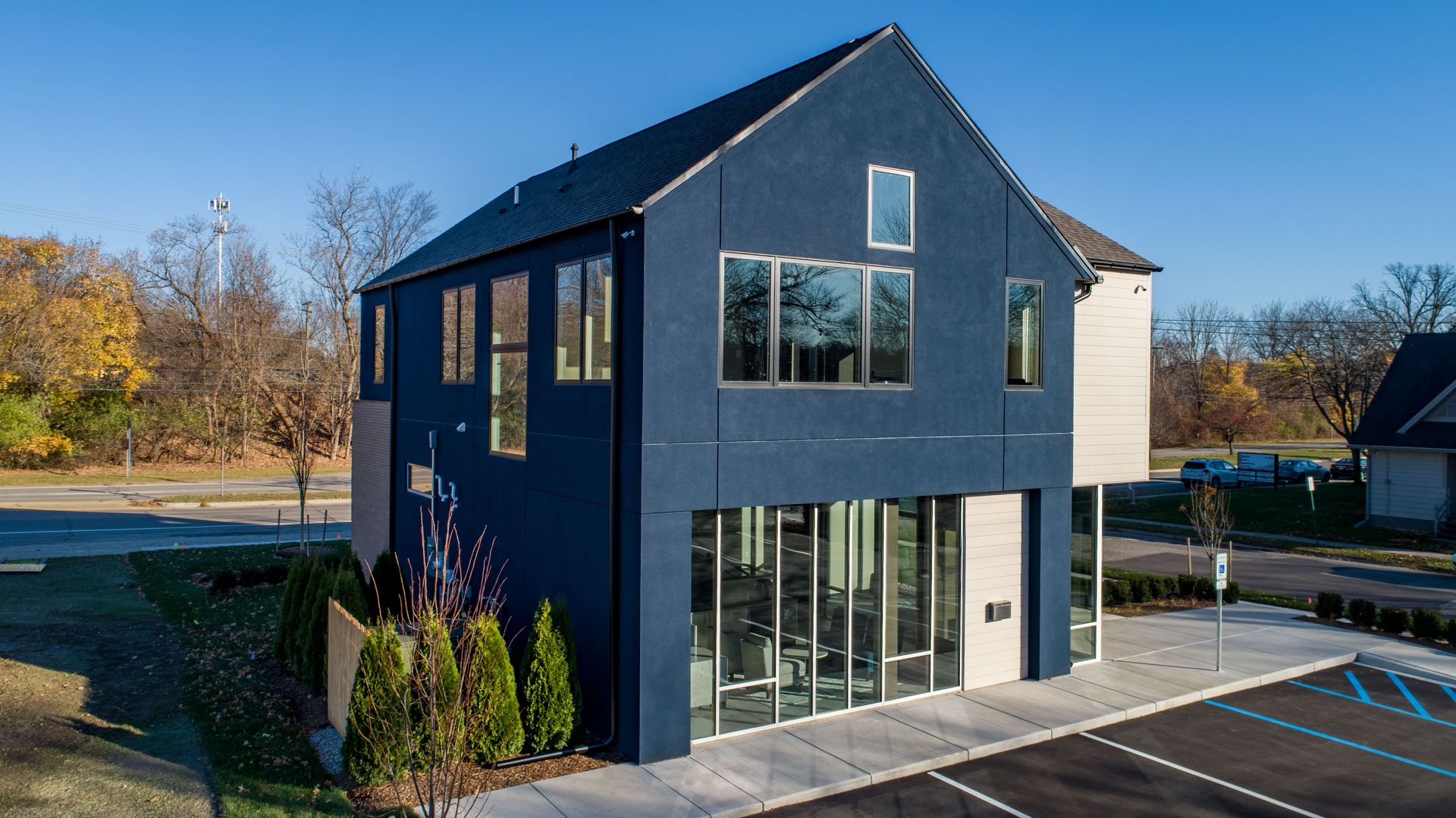 Modern blue building with large windows on a sunny day.