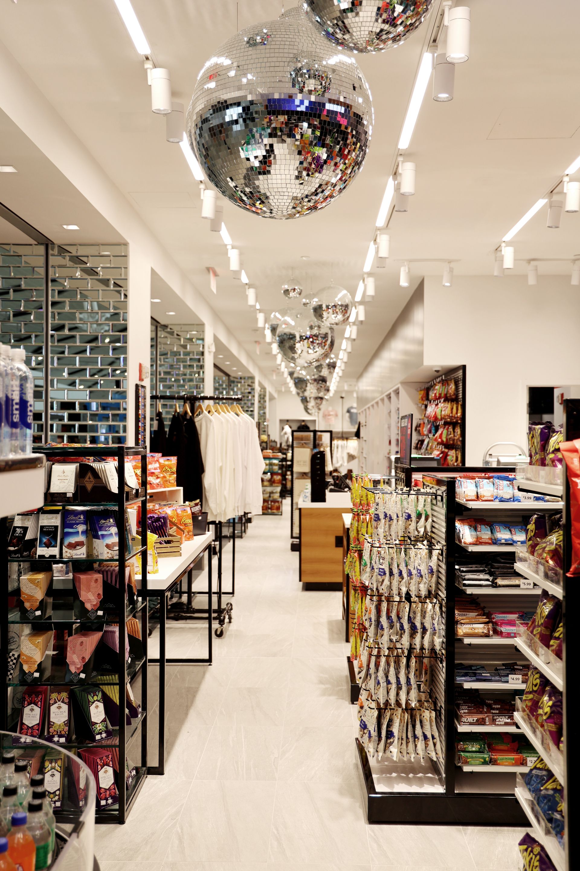 Interior shot of a well-lit store aisle with products on shelves, disco balls hang from the ceiling.