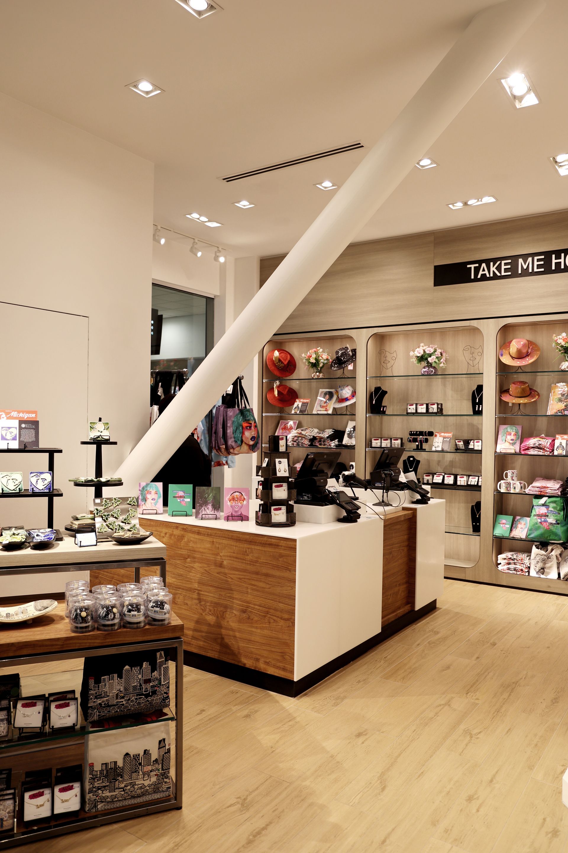 Interior of a retail store with merchandise displays. Counter and support beam visible. Warm lighting.