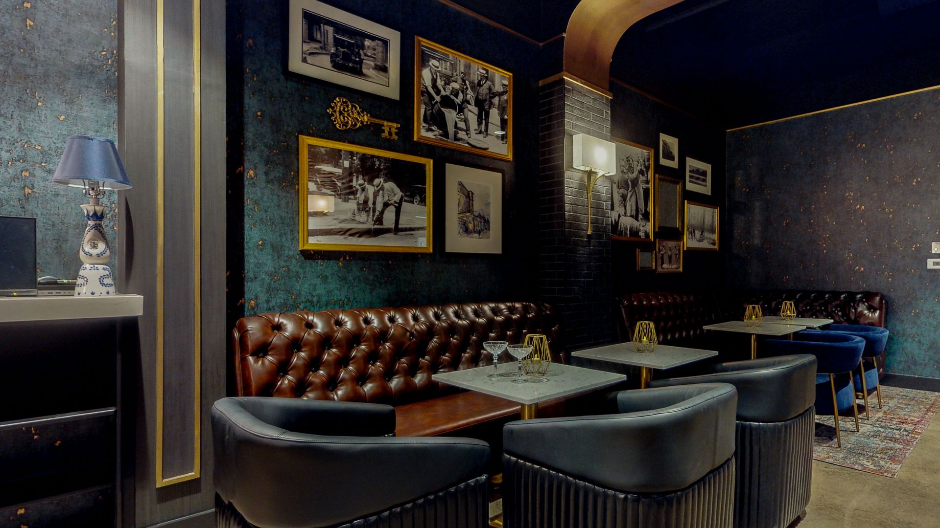 Cozy bar with leather booths, dark walls, and framed photos; gold accents.