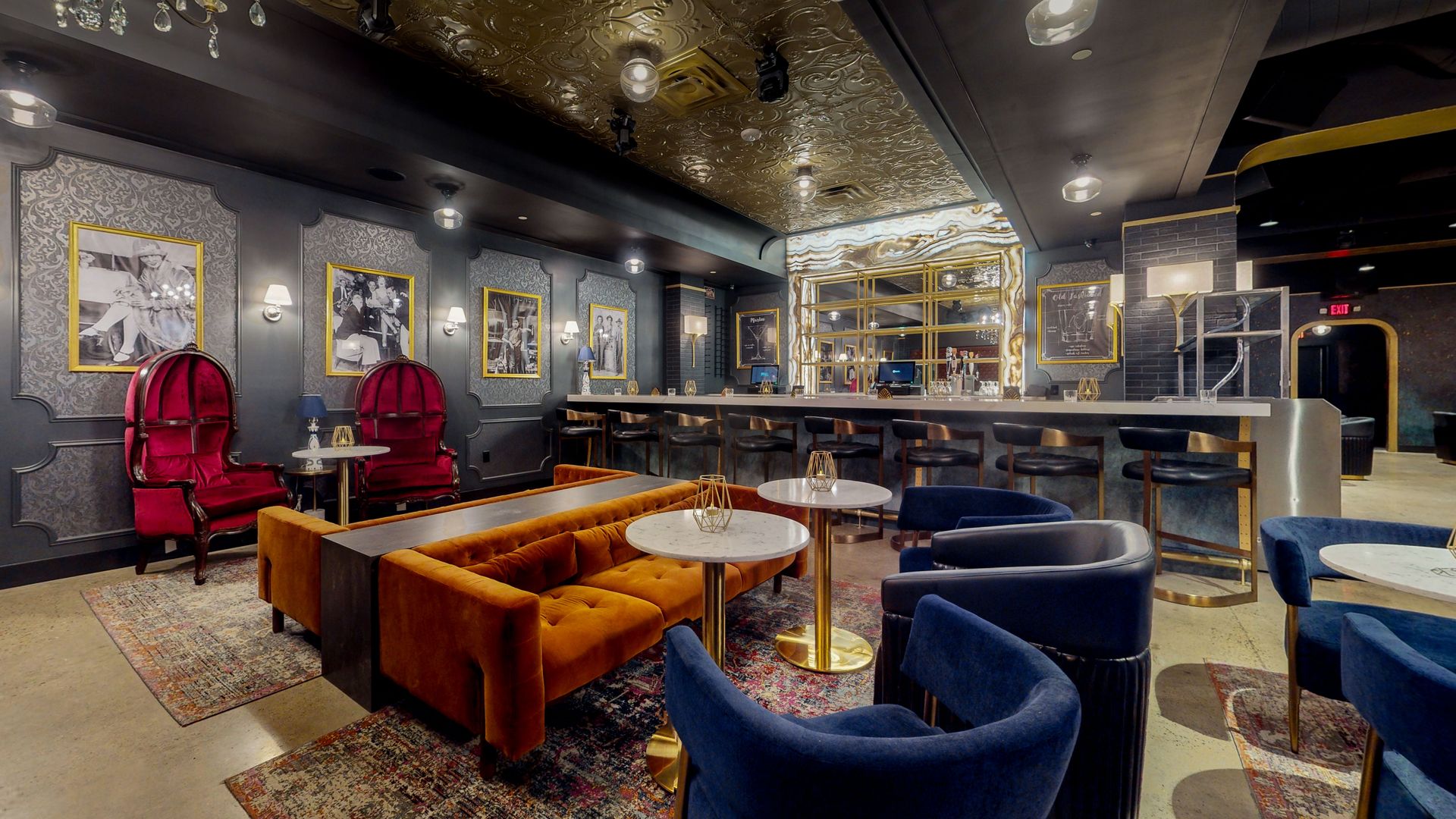 Upscale bar interior with velvet seating, a long bar, and gilded details.