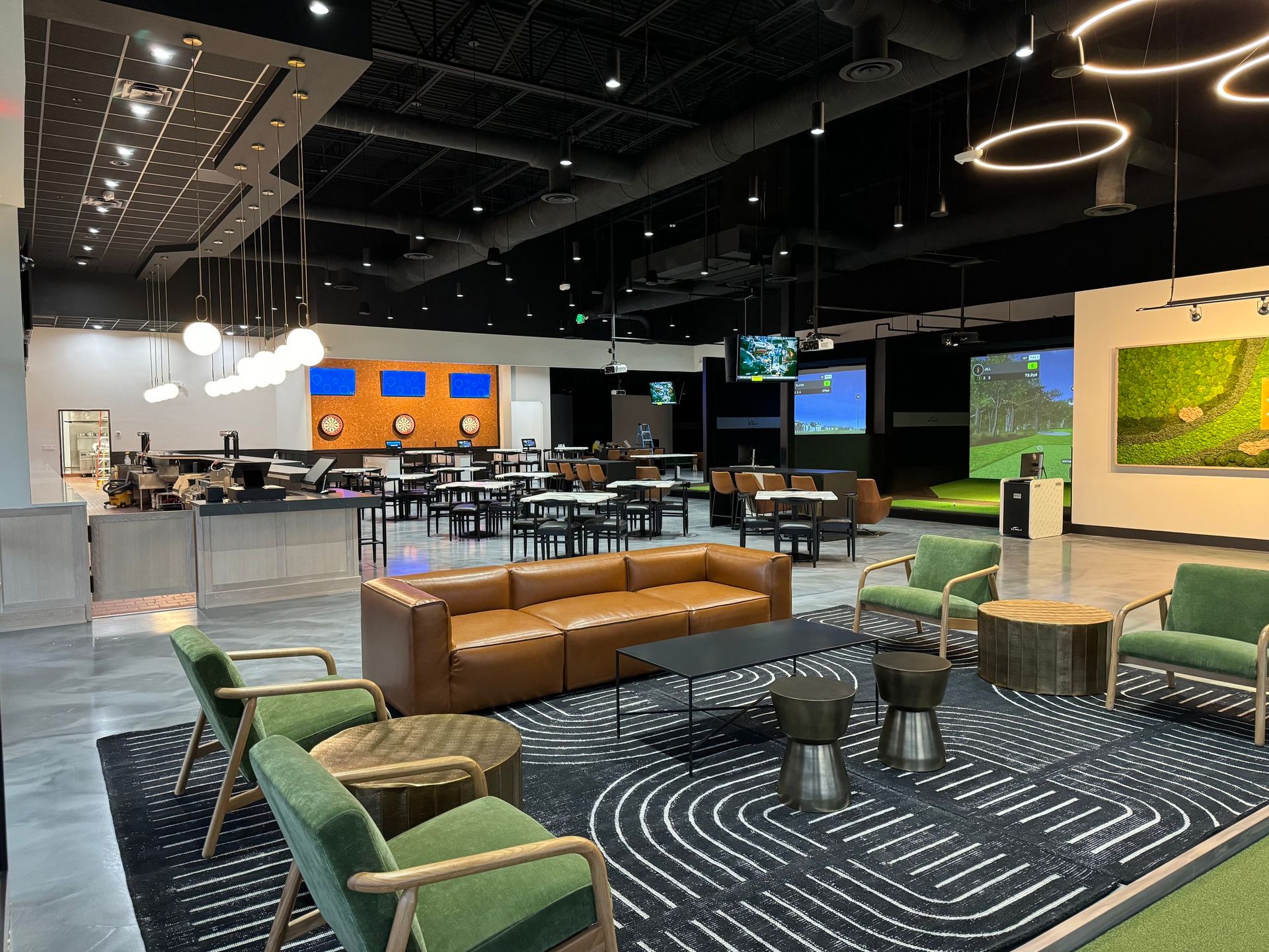 A large room with a lot of tables and chairs and a bar.