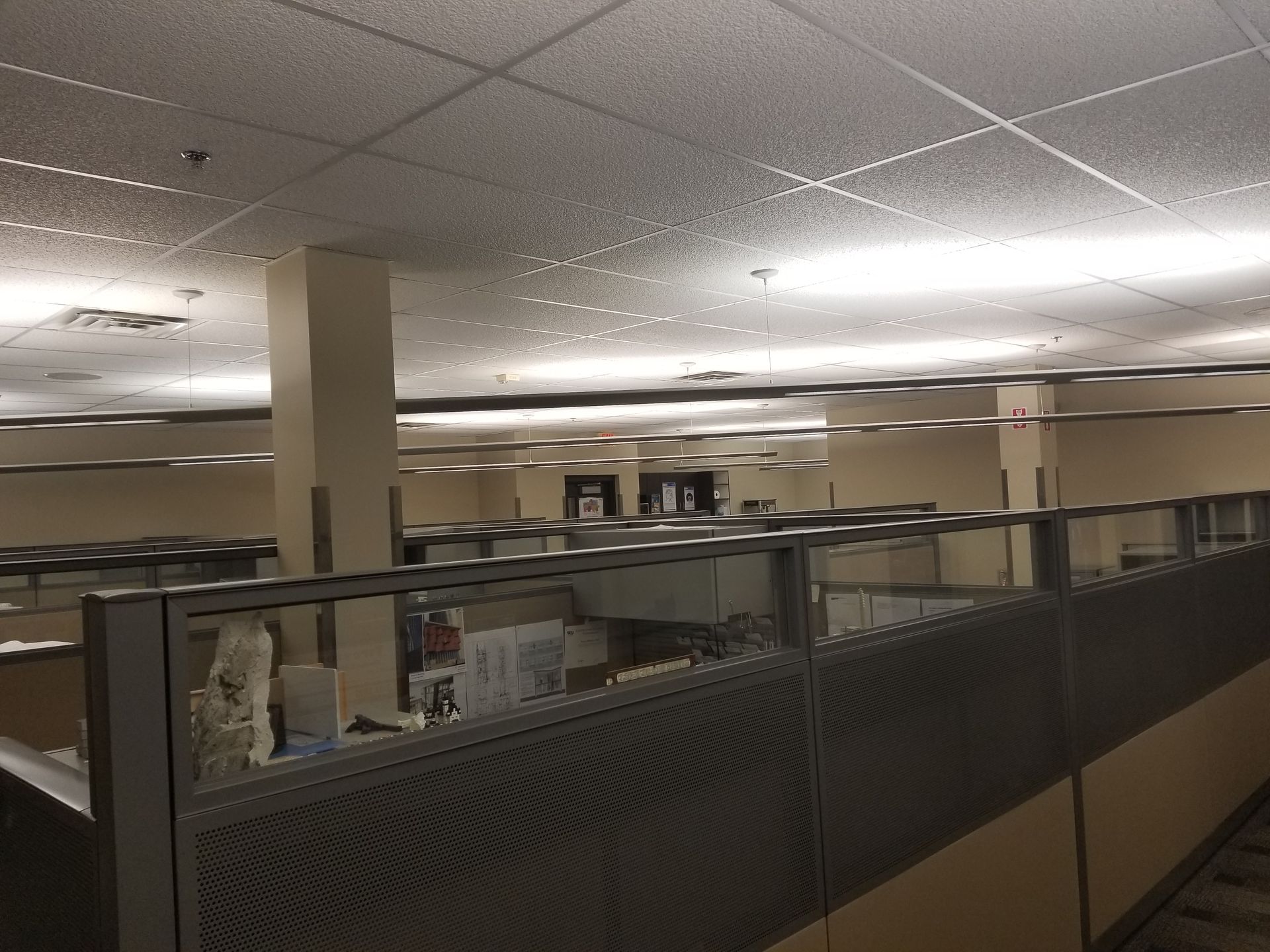 Office cubicles with overhead lighting, neutral tones.