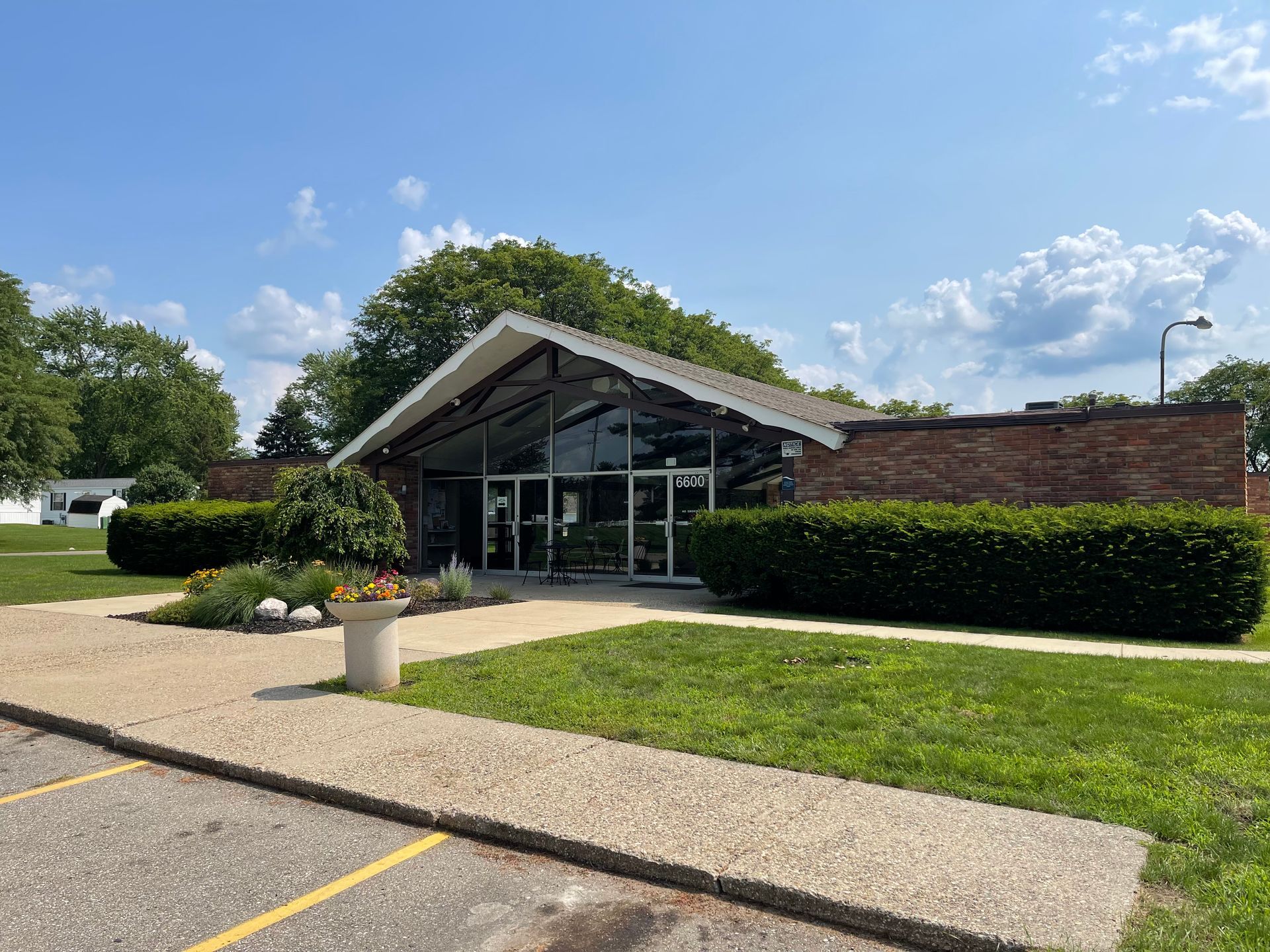 Church building with glass front entrance, brick sides, and manicured landscaping.