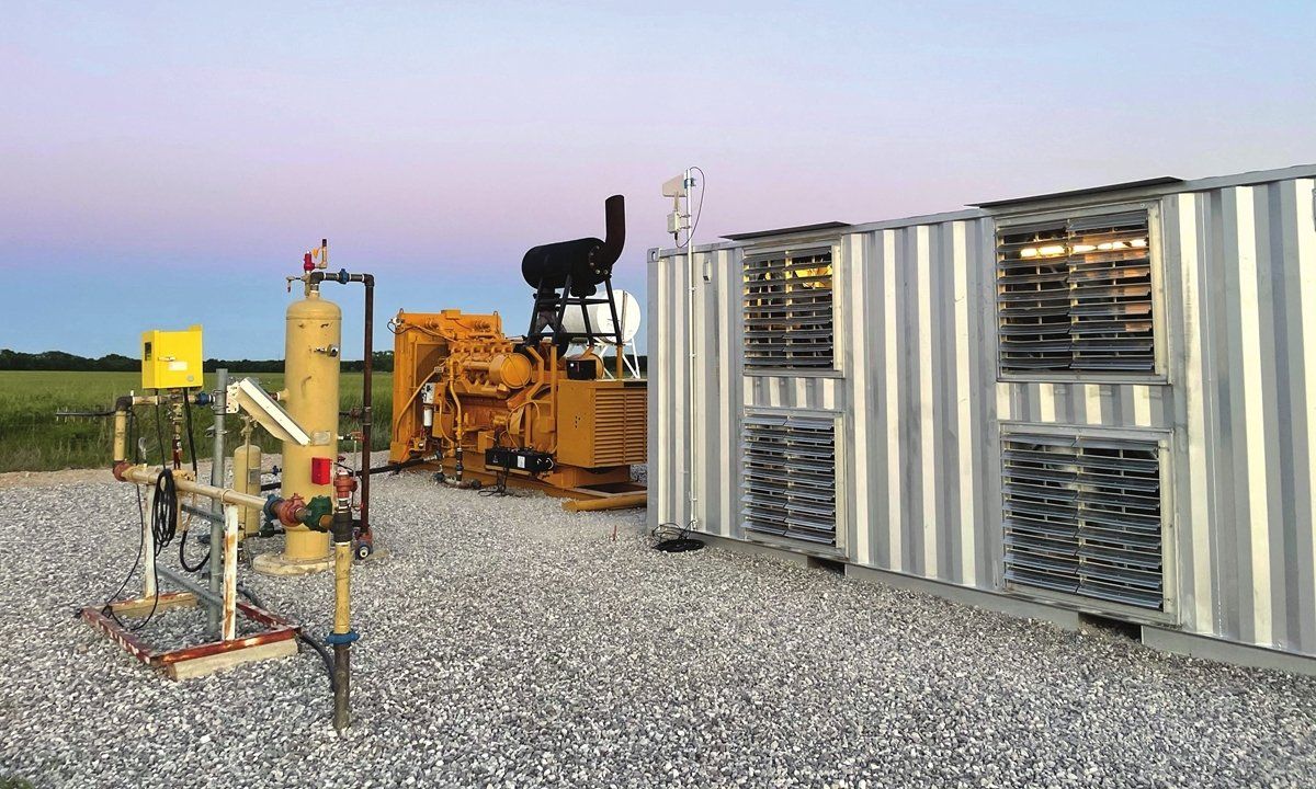 A large container is sitting in the middle of a gravel field.