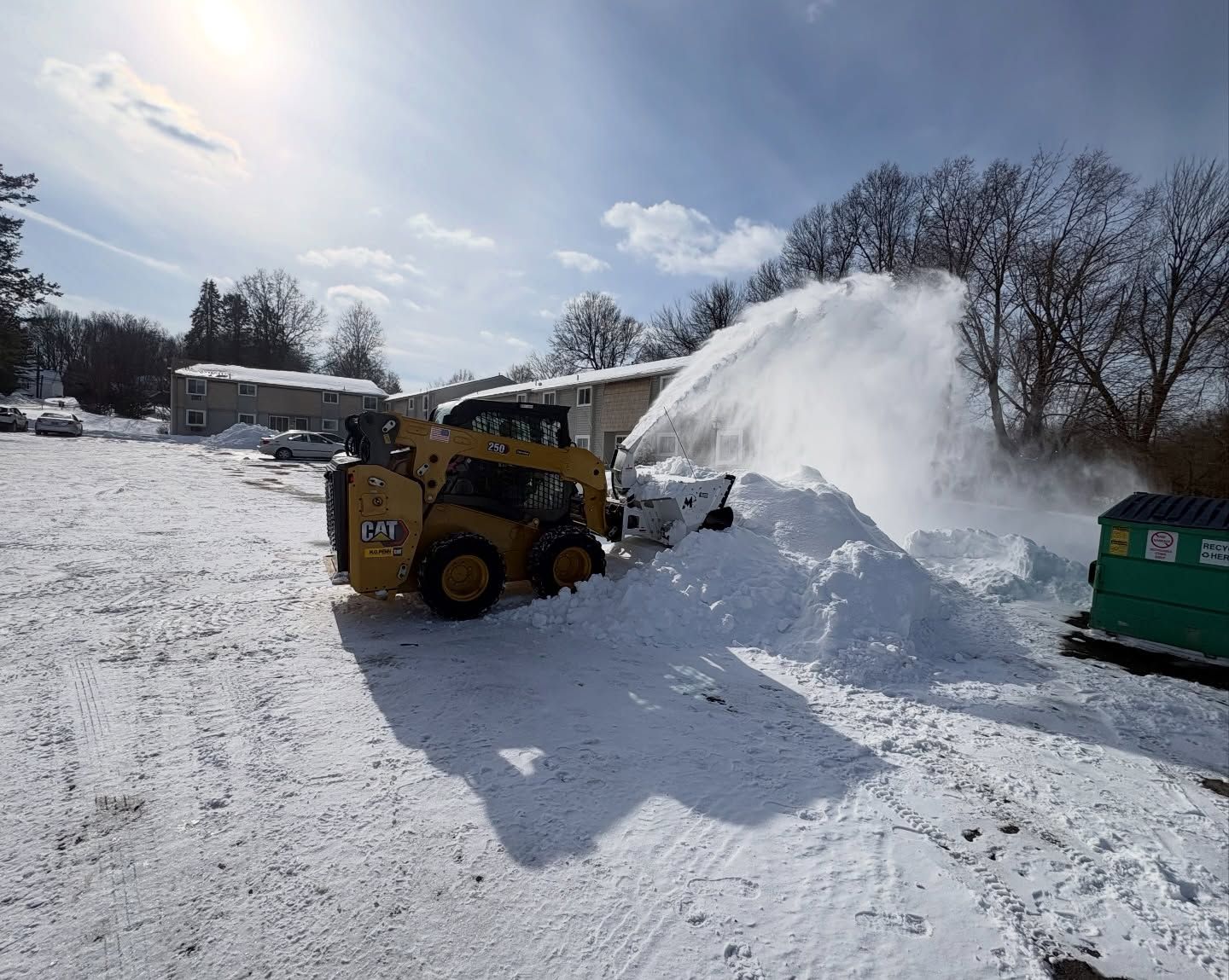 Commercial snow removal in Rocky Hill CT with a skid steer clearing snow from a commercial parking lot