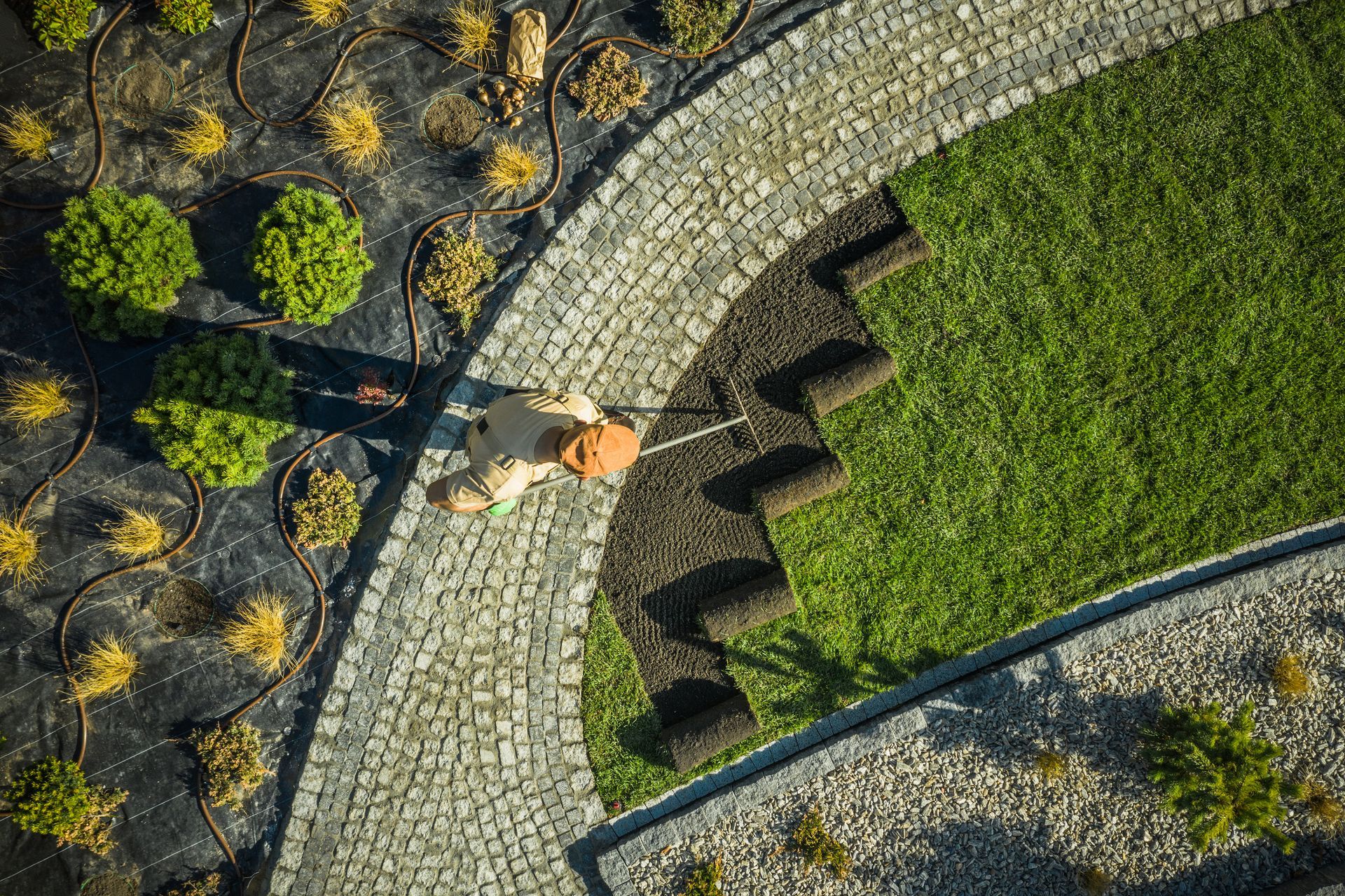 Landscaped key-shaped garden path with stepping stones, red bench, and truck in a parking lot.