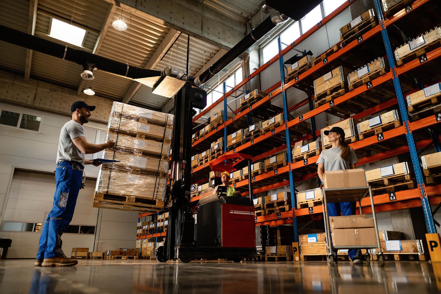 a man is loading boxes onto a forklift in a warehouse .