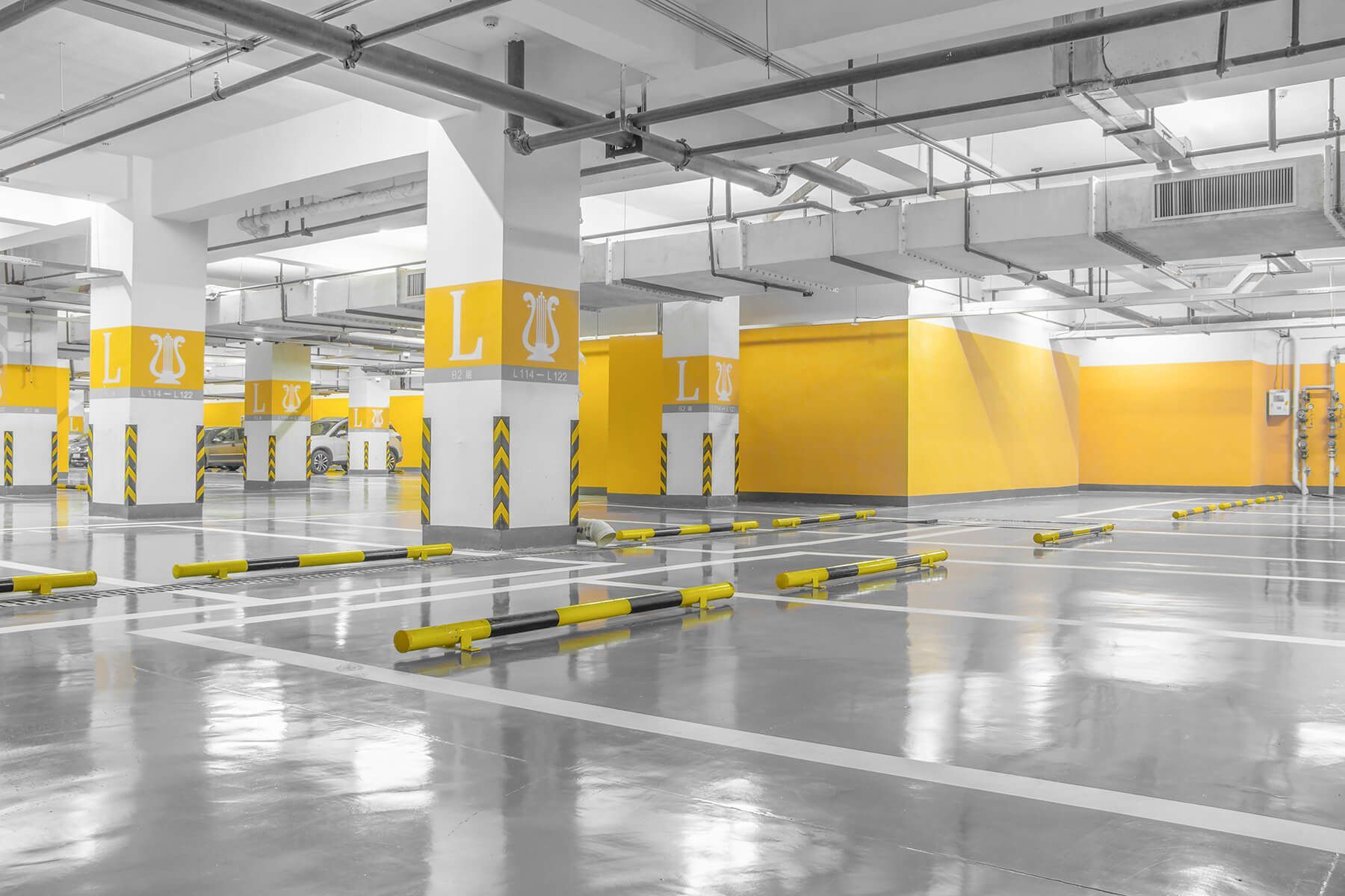 an empty parking garage with yellow walls and columns .