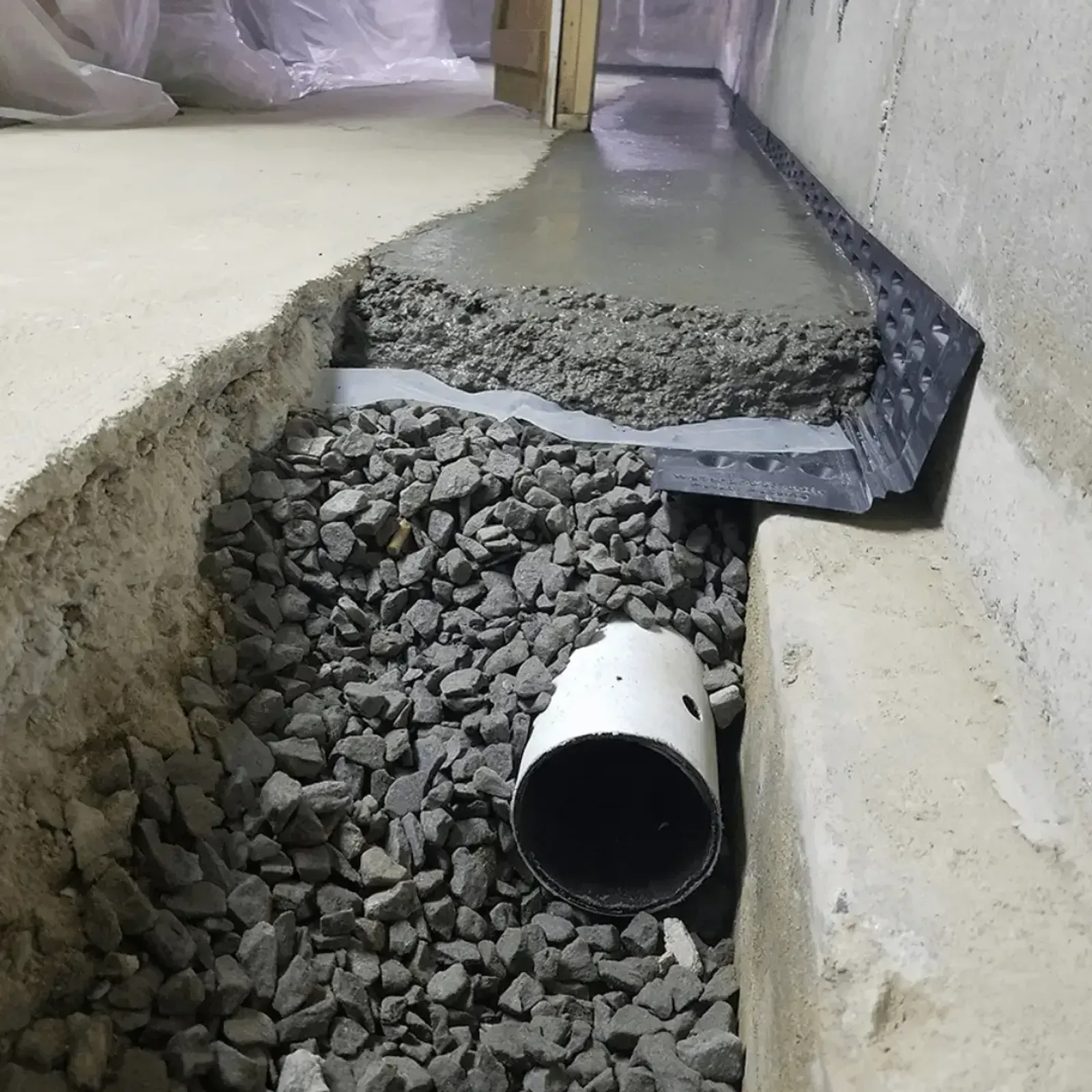 Basement drainage channel with gravel and waterproofing membrane by Elite Basement Solutions