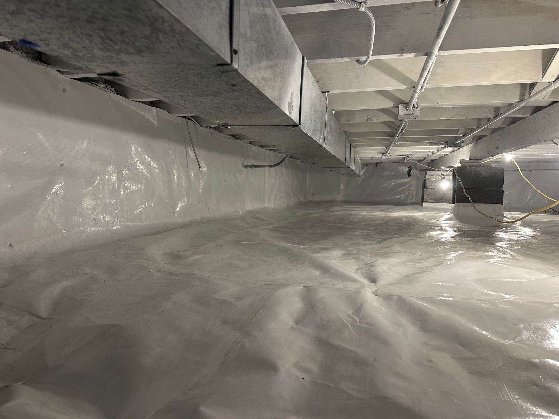 Crawl space encapsulation with sealed walls and vapor barrier flooring by Elite Basement Solutions