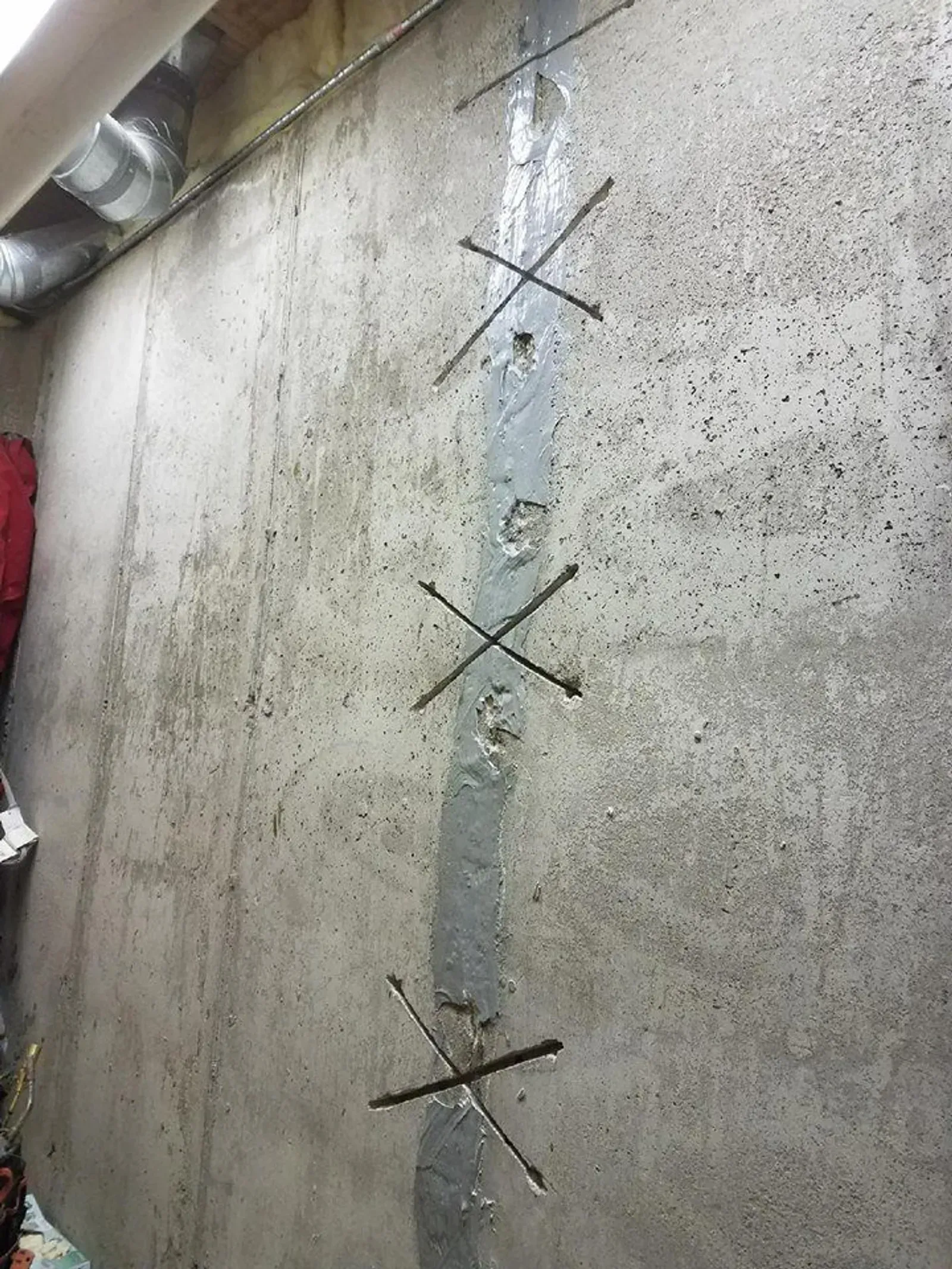 Technician installing interior basement drainage system for Elite Basement Solutions in Bucks County PA