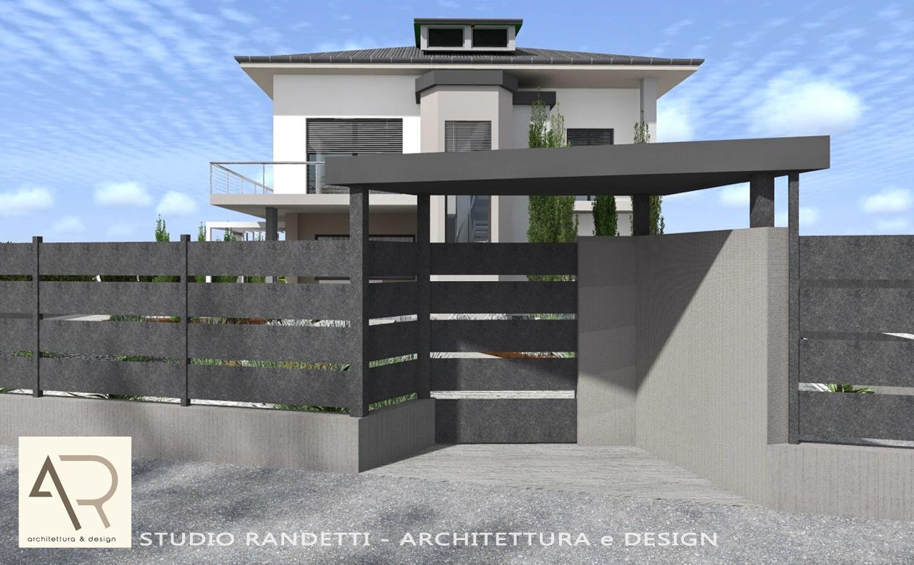 Esterno di una casa moderna con cancello grigio, recinzione scura e vialetto in cemento sotto un cielo azzurro.