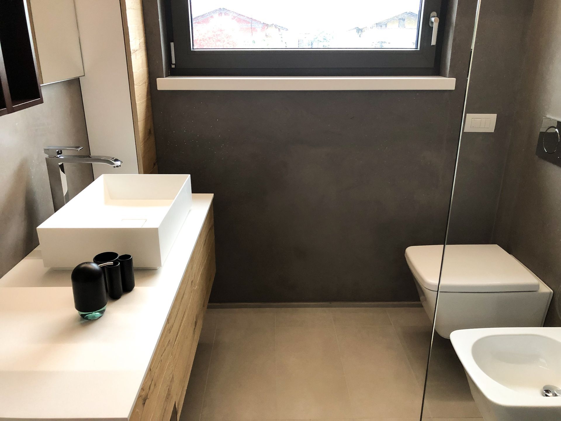 Bagno moderno con doppio lavabo, WC, vasca da bagno e ampia finestra.