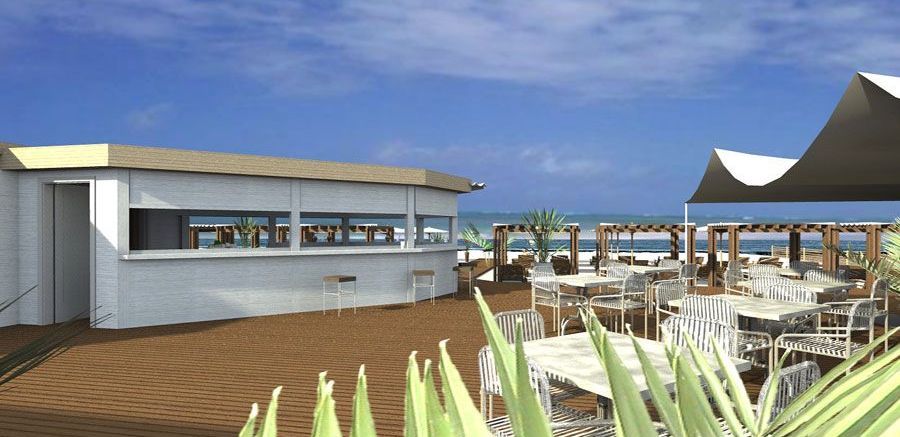 Caffè sulla spiaggia con tavolini in legno sotto gli ombrelloni, con vista sull'oceano.