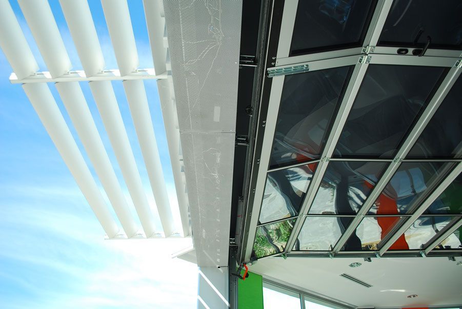 Pannelli solari e lucernari che riflettono la luce brillante del sole sul soffitto di un edificio moderno.