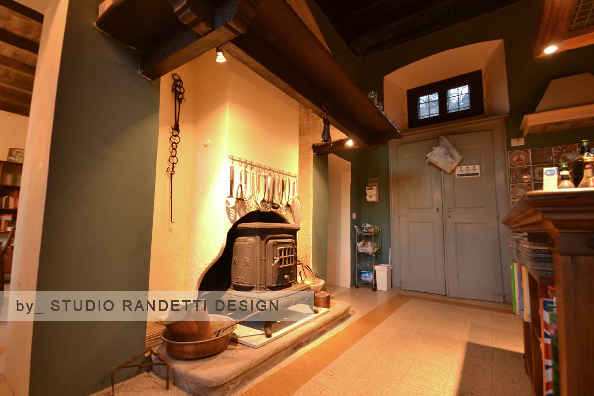 Accogliente soggiorno rustico con camino, travi in legno e una porta grigia sul retro.
