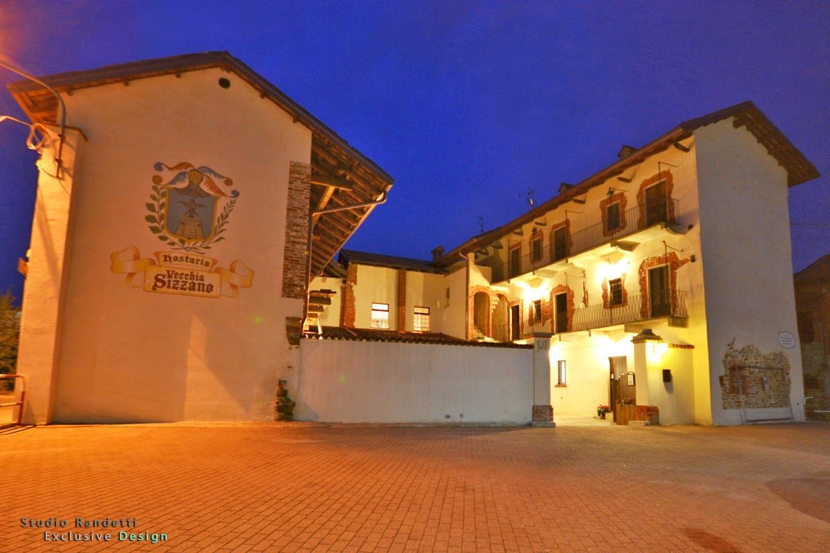 Edificio storico e cortile illuminati al crepuscolo sotto un cielo azzurro