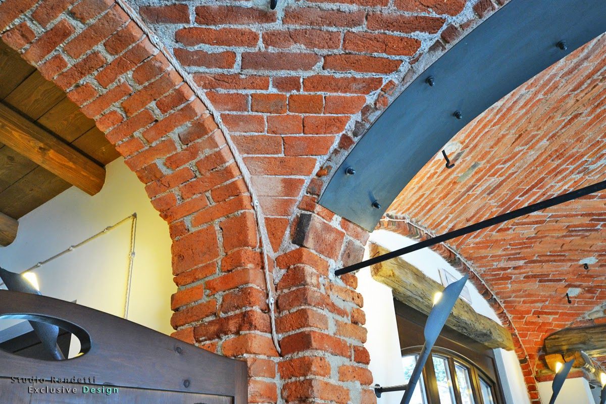 Soffitto a volta in mattoni e archi in un interno rustico con travi a vista e sezione dipinta di blu