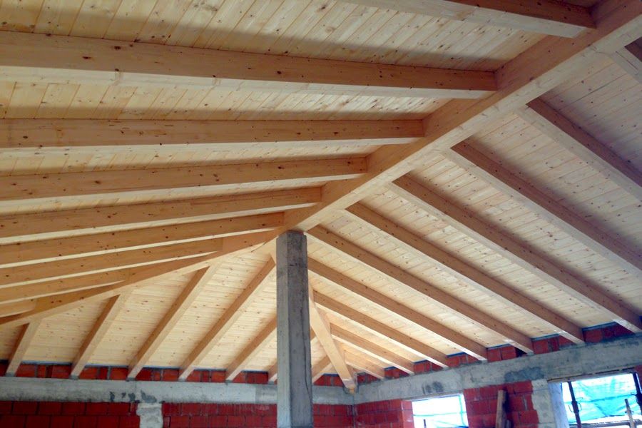 Tetto a volta in legno con travi a vista all'interno di un edificio in costruzione