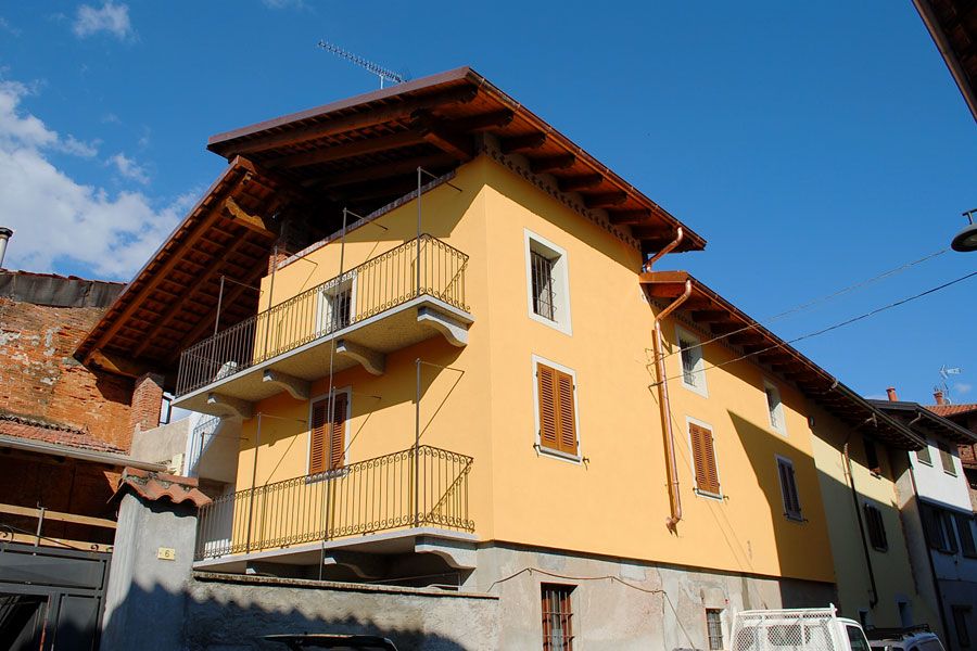 Palazzo di appartamenti giallo con balconi sotto un cielo azzurro