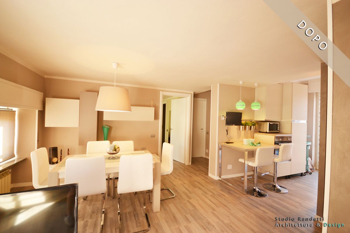 Moderna zona pranzo e cucina a pianta aperta con sedie bianche, pareti beige, pavimento in legno e lampade a sospensione verdi.