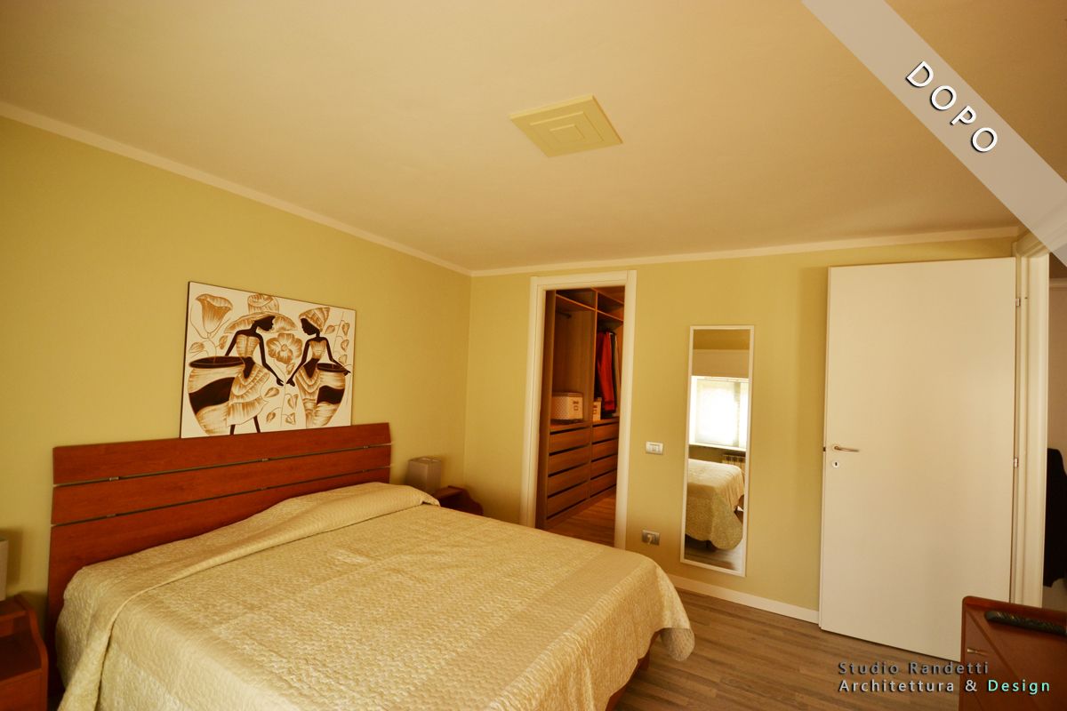 Camera da letto con letto, comò, specchio e ante dell'armadio bianche in calde tonalità beige.