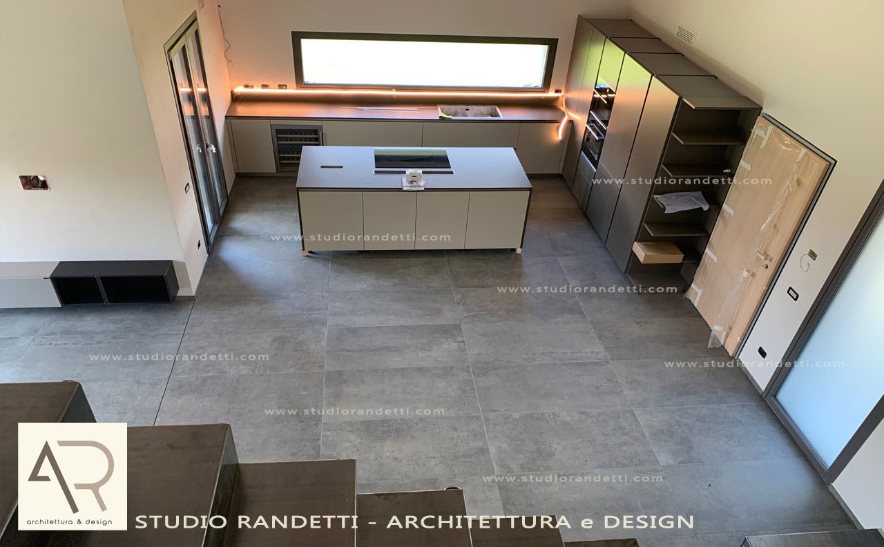 Cucina moderna con isola, elettrodomestici a incasso e ampia finestra sopra il lavello.