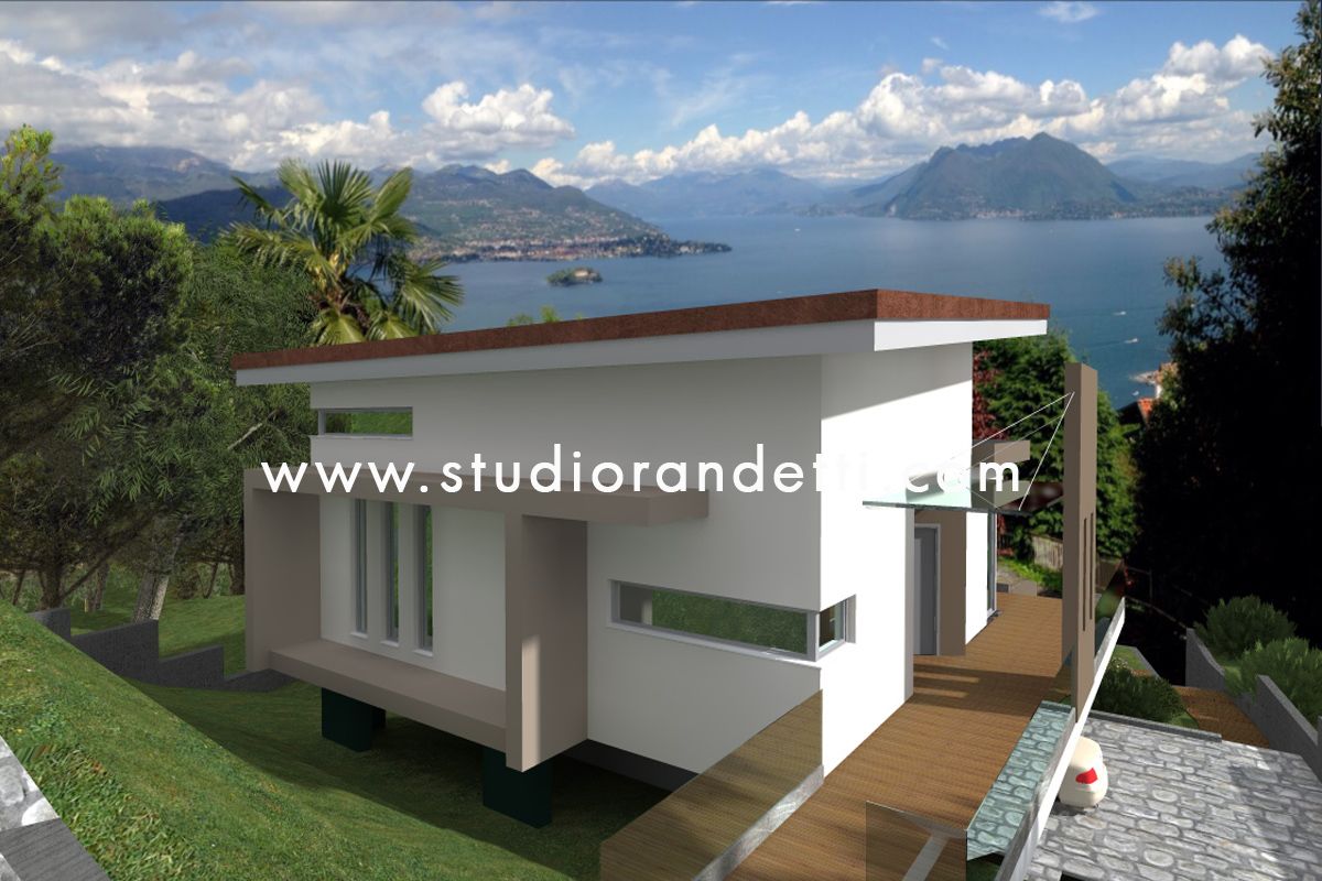 Casa moderna bianca con terrazza in legno affacciata su un lago e sulle montagne sotto un cielo azzurro nuvoloso.
