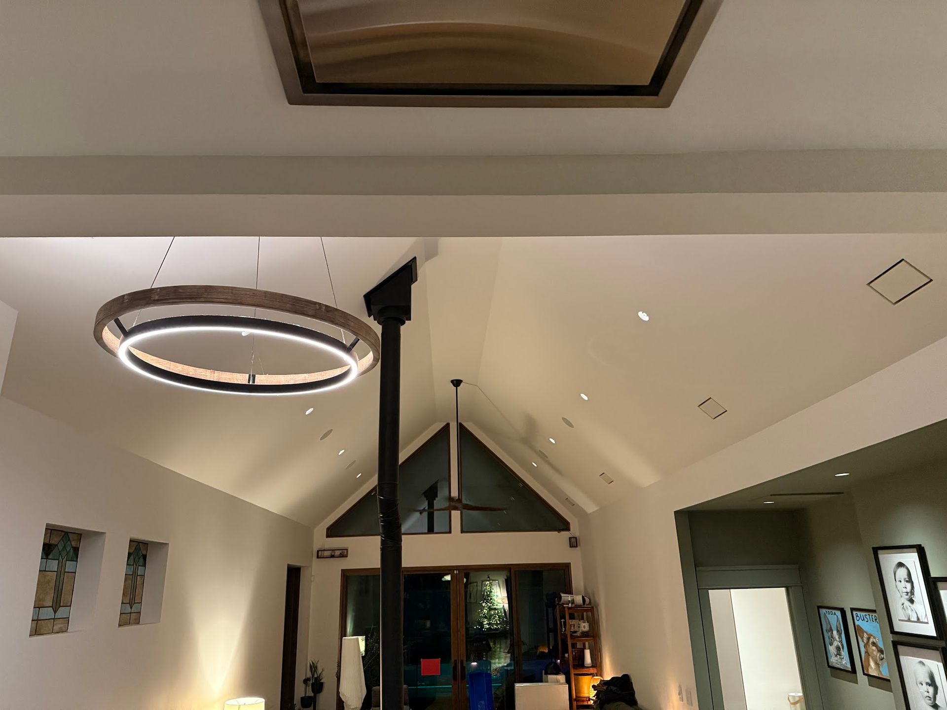 Modern interior: vaulted ceiling with skylight, large light fixture, and recessed lighting.