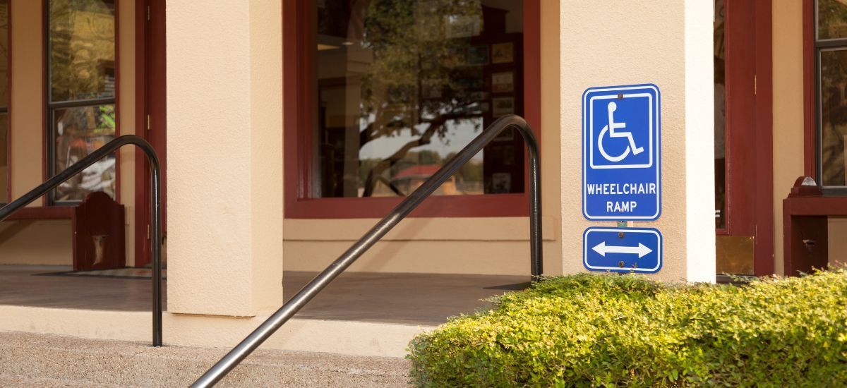 Wheelchair ramp sign posted on a wall