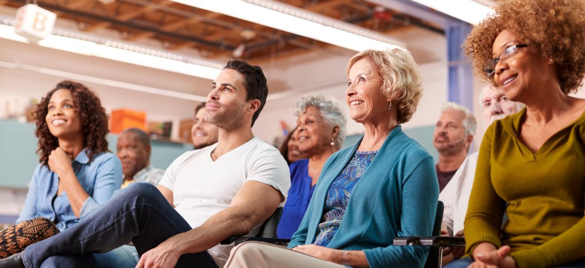A group of people sitting in the audience of a presentation