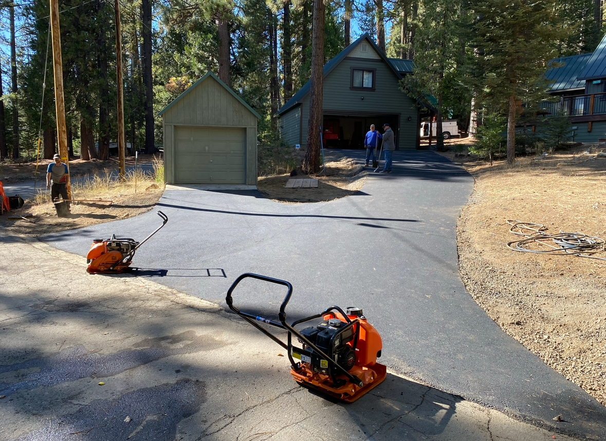 A machine is sitting on the side of a road in front of a house.