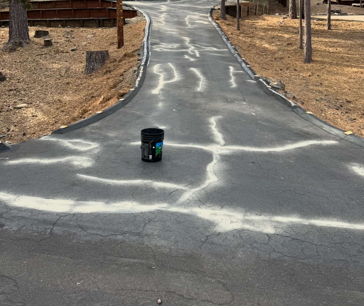 A black bucket sits on the side of a road