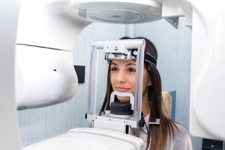 Woman undergoing eye exam in optical machine at a clinic