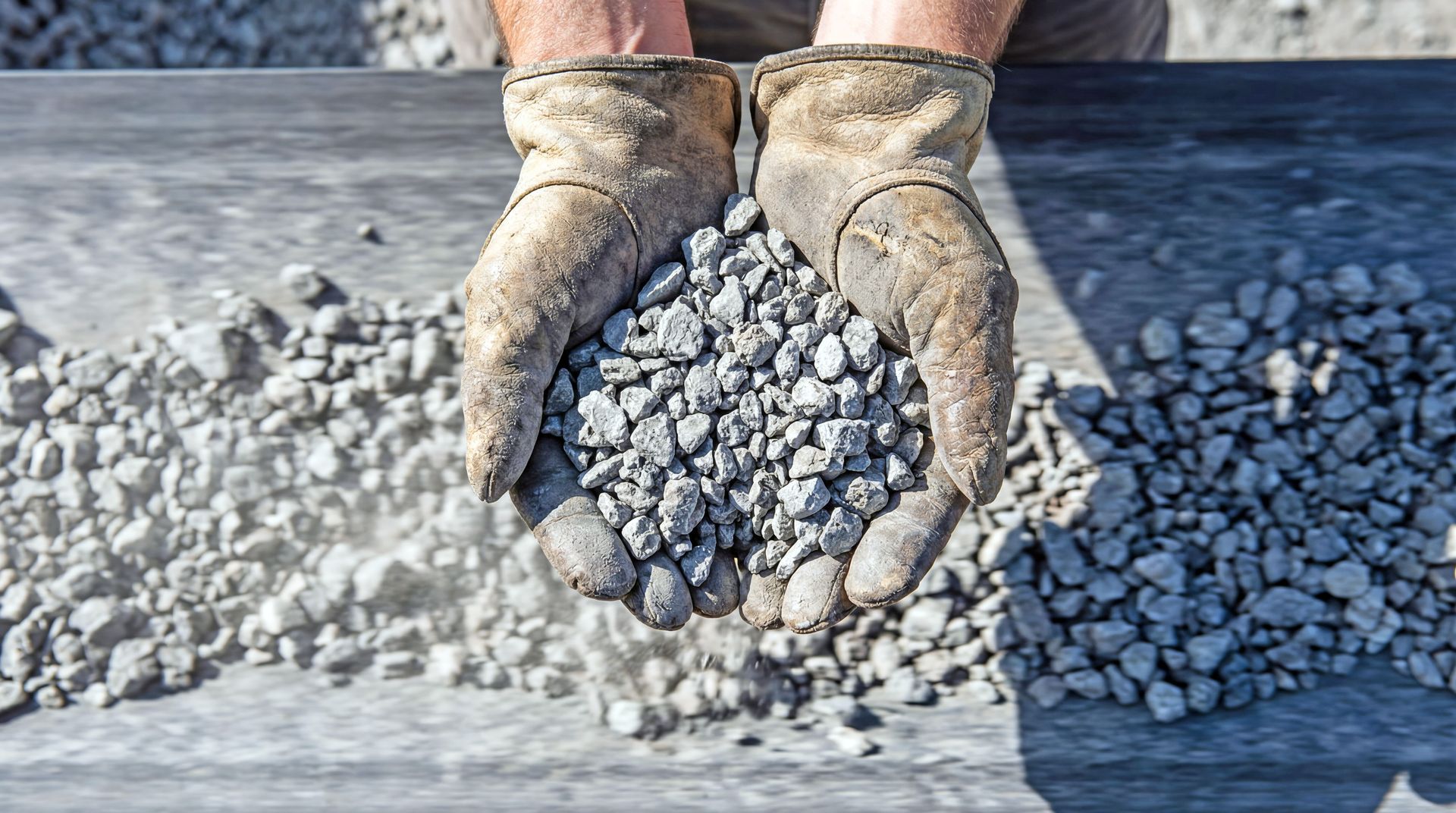 Gloved hands holding a pile of small gravel stones at a construction site. Gloved hands holding a pile of small gravel stones at a construction site.