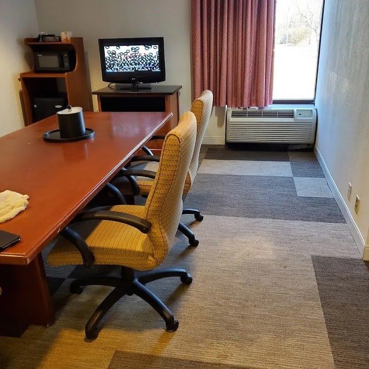 A conference room with a table and chairs and a television