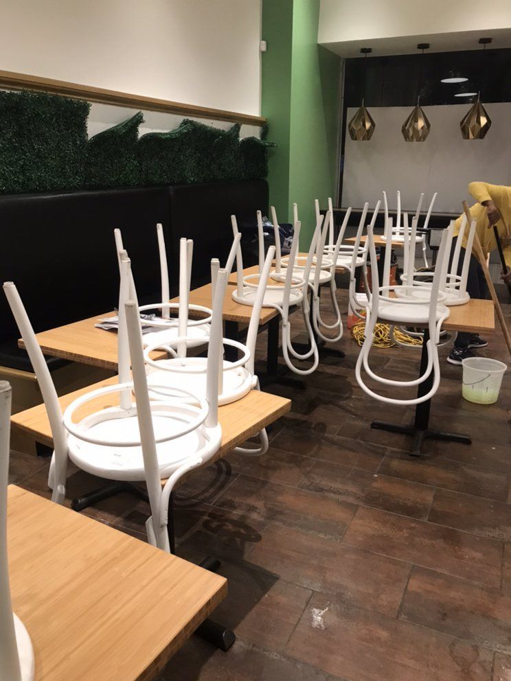 A restaurant with tables and chairs stacked on top of each other.