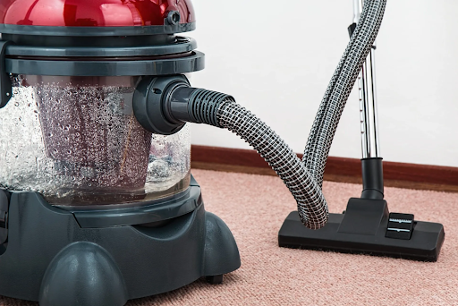 A vacuum cleaner is sitting on a carpet in a room.