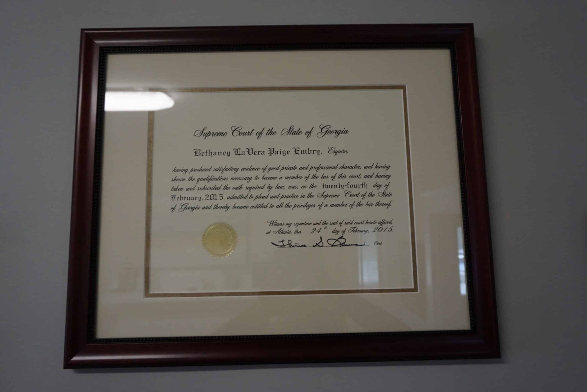 Framed certificate or diploma with gold seal hanging on a wall