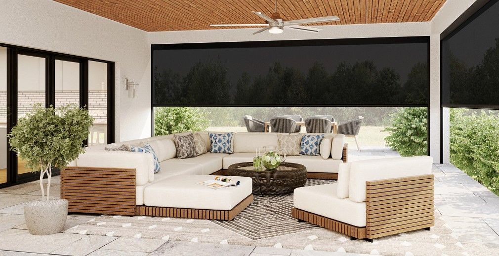 Outdoor patio with sectional sofa, coffee table, and black sun shades.