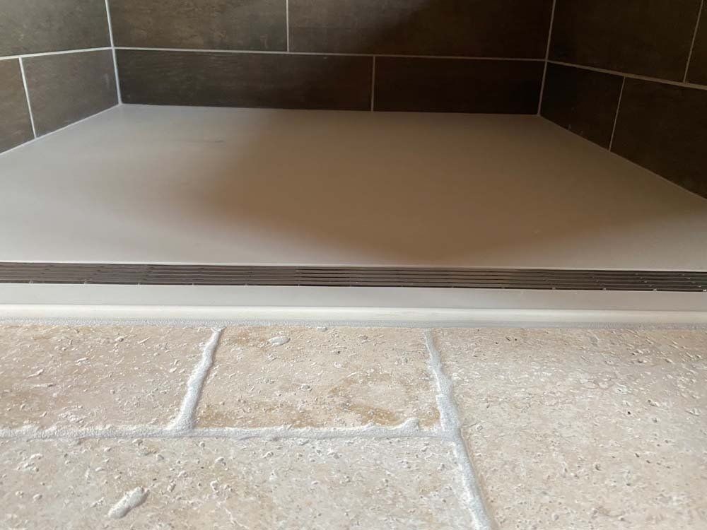 Stone floor transitions to a light-colored platform with dark tile backdrop.