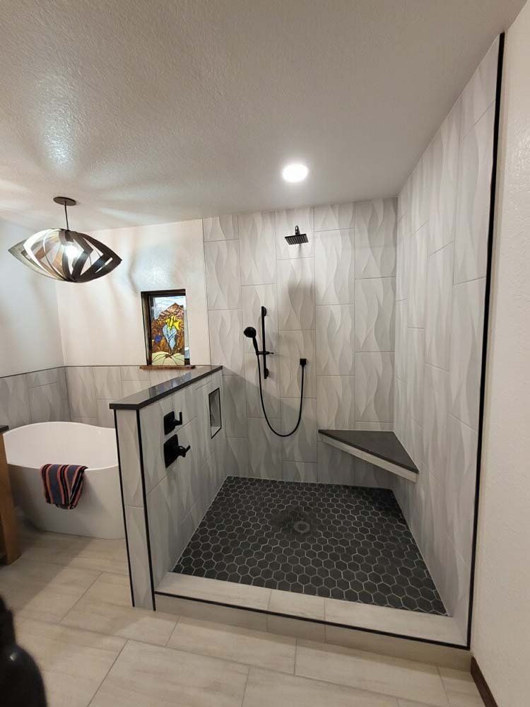 Modern bathroom with walk-in shower. Hexagon tile floor, wave-patterned wall tile.