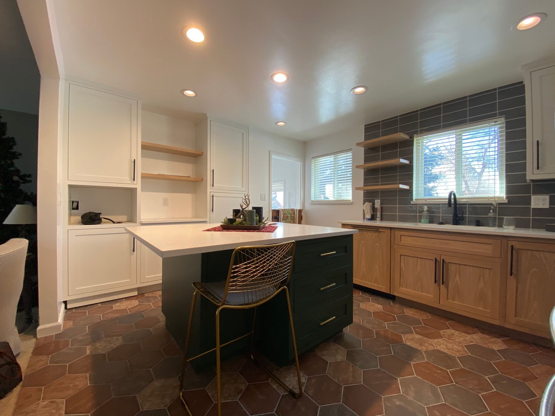Kitchen with white cabinets, green island, and wood lower cabinets, hexagon floor.
