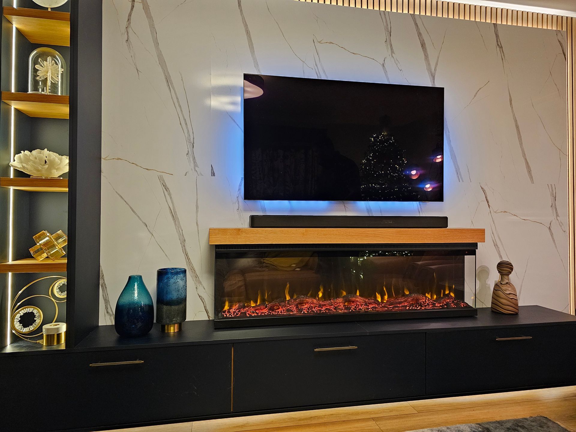 Bespoke fitted media wall with LED lighting and marble-effect backdrop by QM Furniture