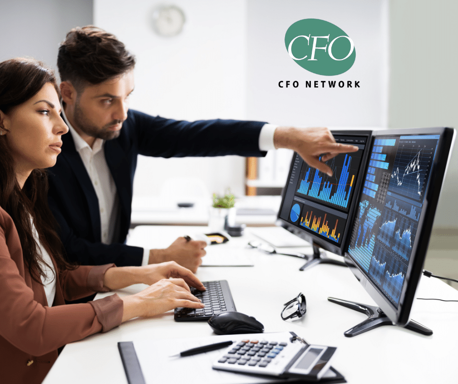 A man and a woman are sitting at a desk looking at a financial statement.